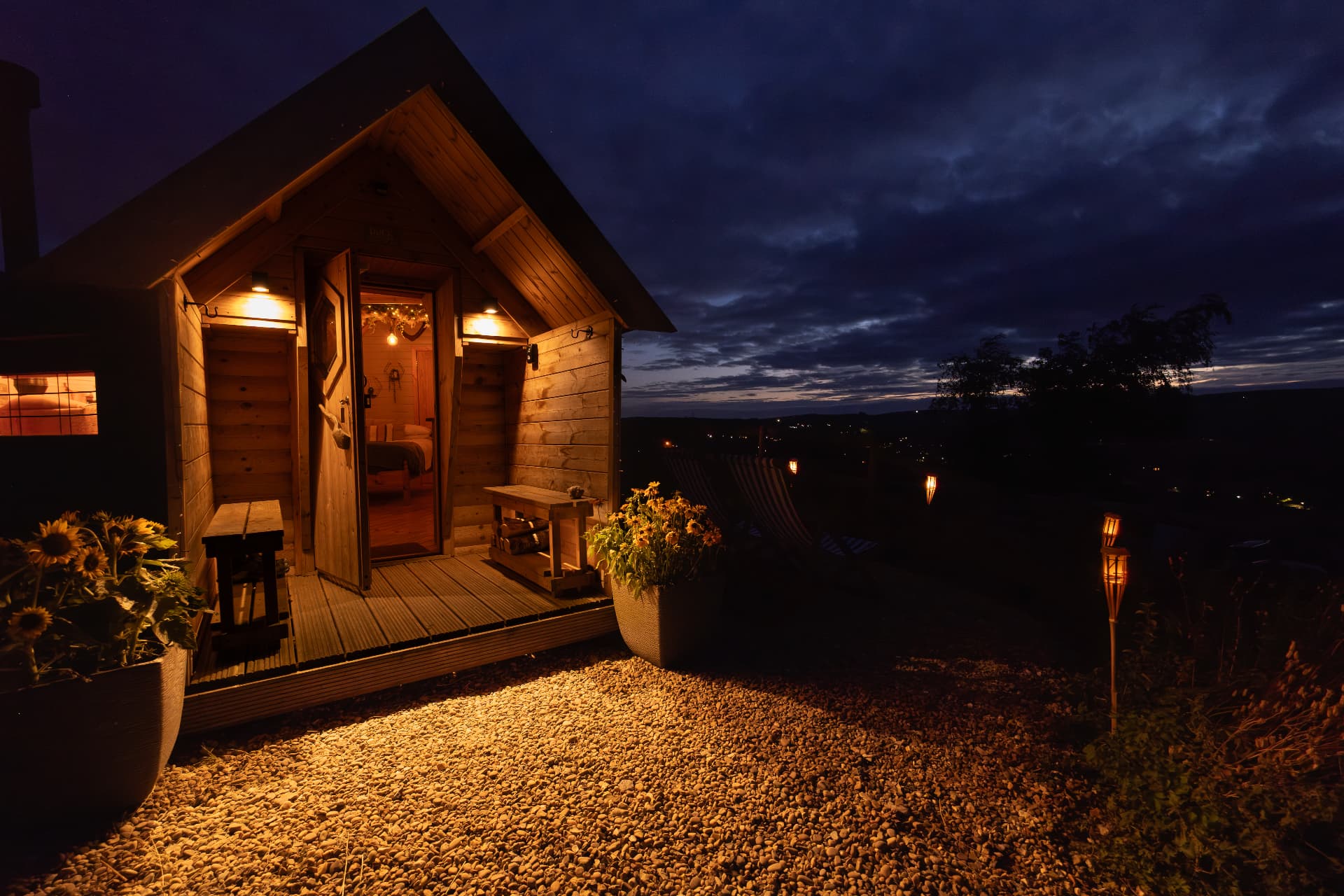 The Mallard lit up at dusk, its door open to the deck and the valley lights beyond