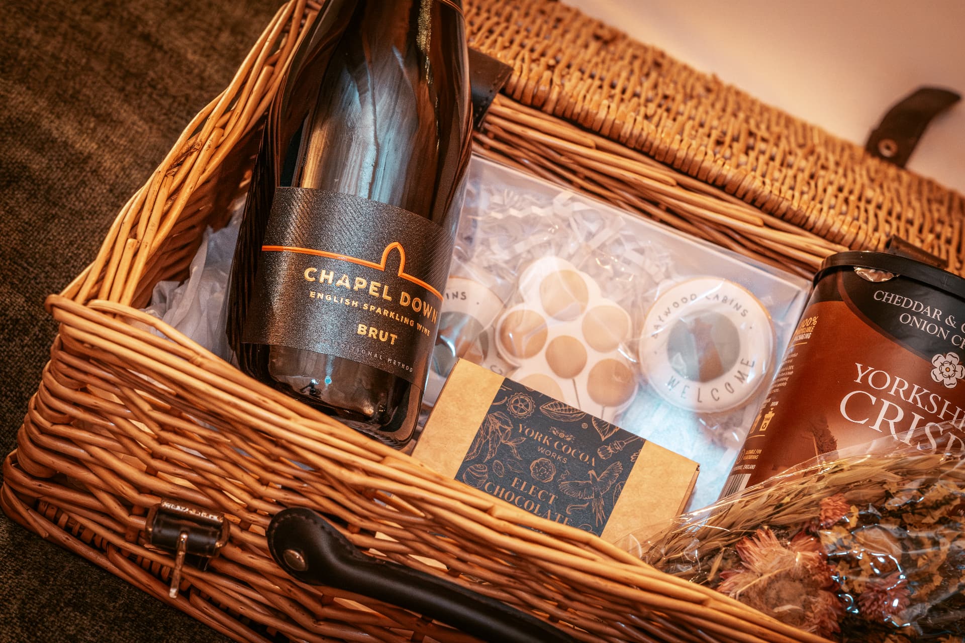 A wicker hamper with English sparkling wine, Yorkshire chocolate and crisps